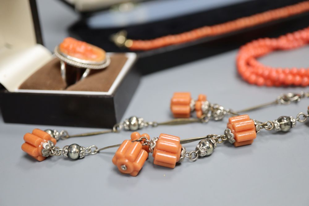 A white metal and carved coral set oval dress ring and three assorted necklaces.